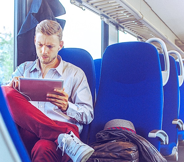 Man on train with a tablet in hands